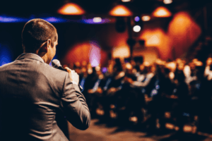 présentateur vu de dos lors d'un congrès d'entreprise dans une salle remplie